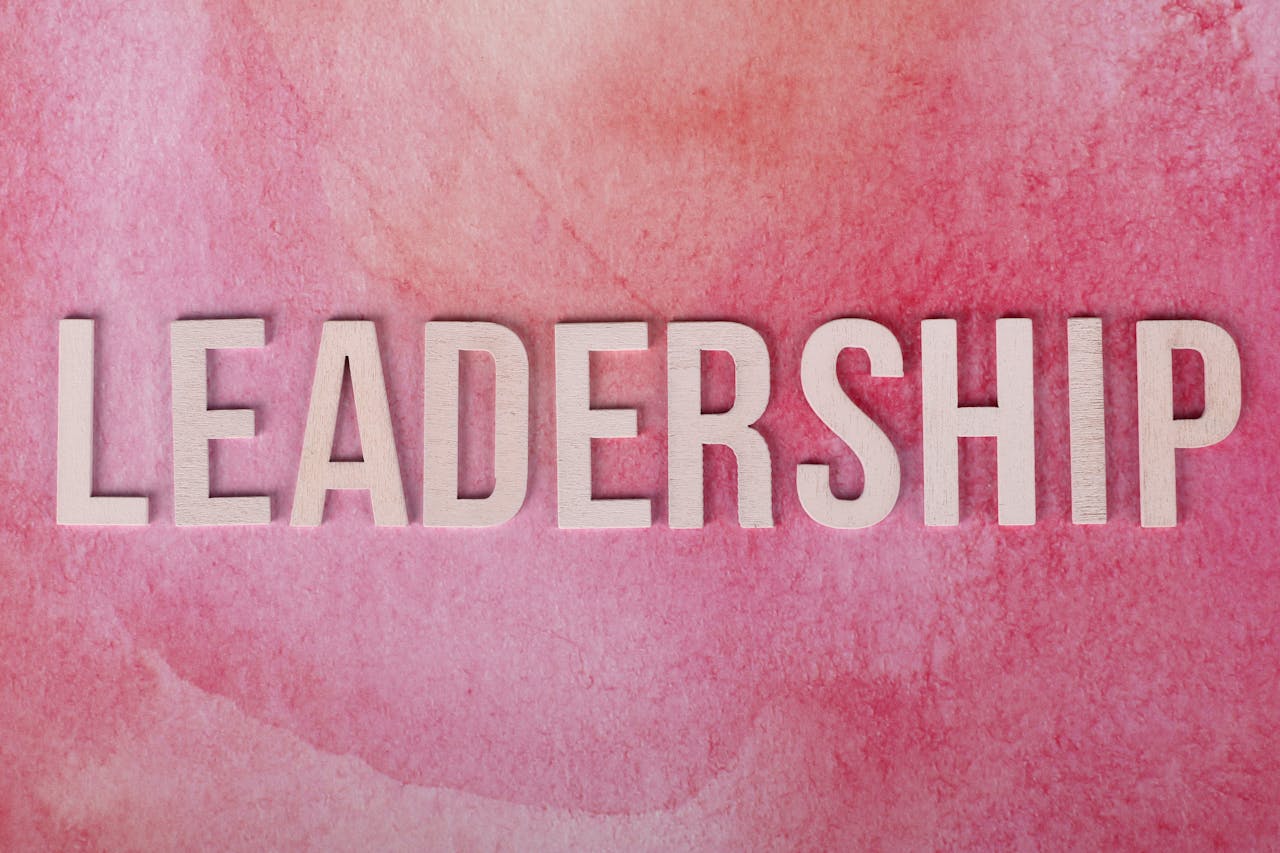 Inspirational leadership text on a vibrant pink watercolor background.
